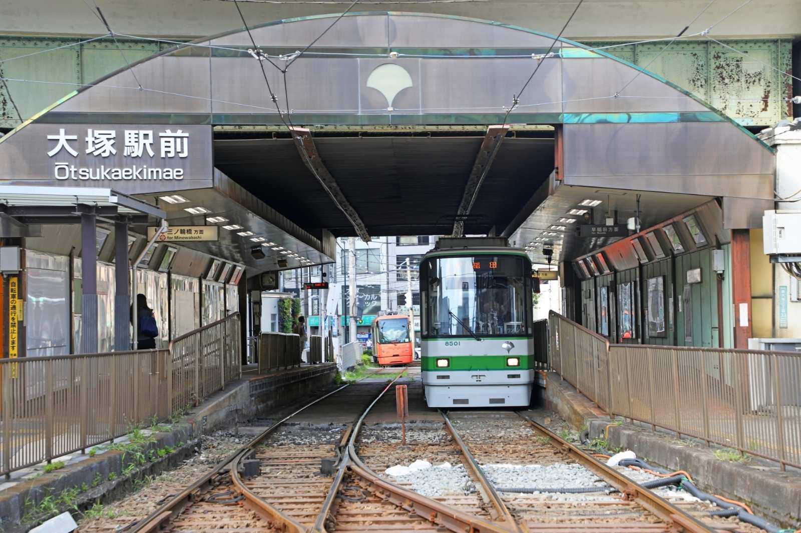 大塚駅前の電停。屋根のある停留所に都電が停車している様子
