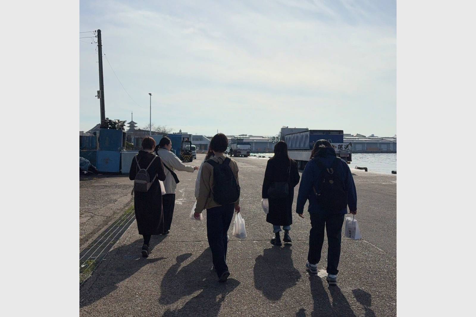 海を背景にした後ろ姿のグループショット